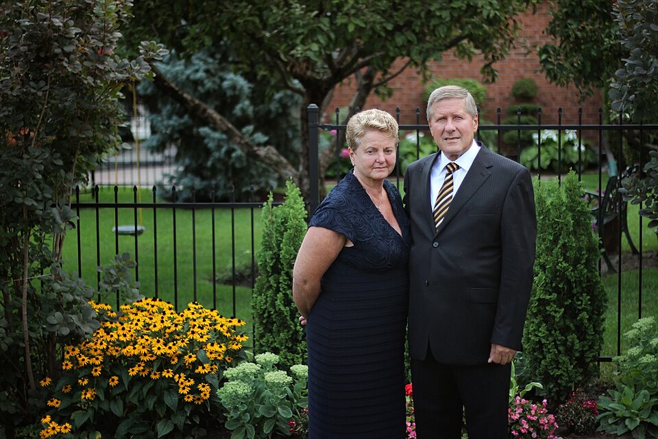 A Polish man and woman standing together in their backyard.