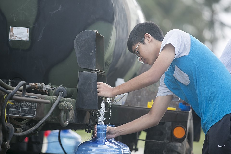 A young boy fills a water jug while U.S. Marines with Combat Logistics Battalion 31, 31st Marine Expeditionary Unit, distribute water to local civilians during typhoon relief efforts in Saipan, Aug. 13, 2015. The Marines and sailors of the 31st MEU assisted the people of Saipan by producing and dist