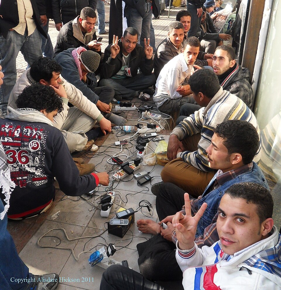 10 February 2011.   One of the biggest problems with using a camera or phone during the revolution was running out of power and being far from home or any power point.  Here a shop allows protesters to use their supply to charge up phones.  This photograph was used for the cover of  "Democracy's Fo