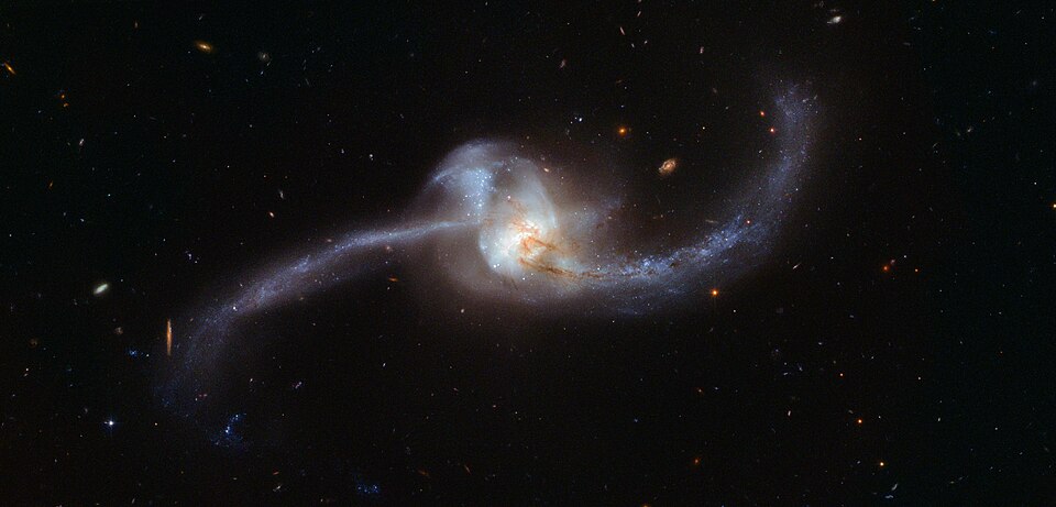 This image, captured by the NASA/ESA Hubble Space Telescope, shows what happens when two galaxies become one. The twisted cosmic knot seen here is NGC 2623 — or Arp 243 — and is located about 250 million light-years away in the constellation of Cancer (The Crab).  NGC 2623 gained its unusual and dis