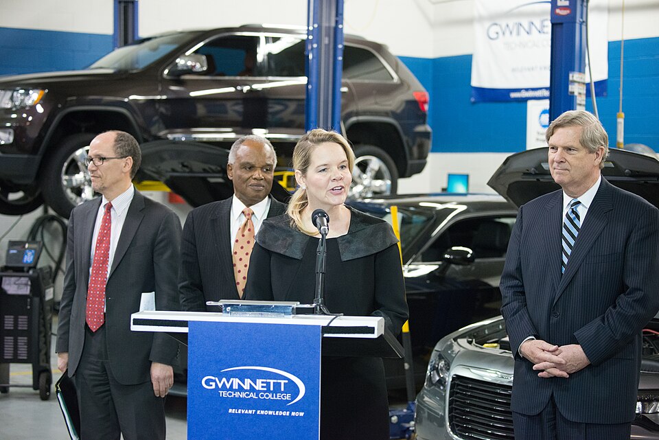 Technical College System of Georgia Commissioner Gretchen Corbin (at podium) makes opening remarks at Gwinnett Technical College, in Lawrenceville, GA, on Friday, Mar. 20, 2015. (L to R Standing  Labor Secretary Thomas E. Perez, Congressman David Scott (GA), and Agriculture Secretary Tom Vilsack). T
