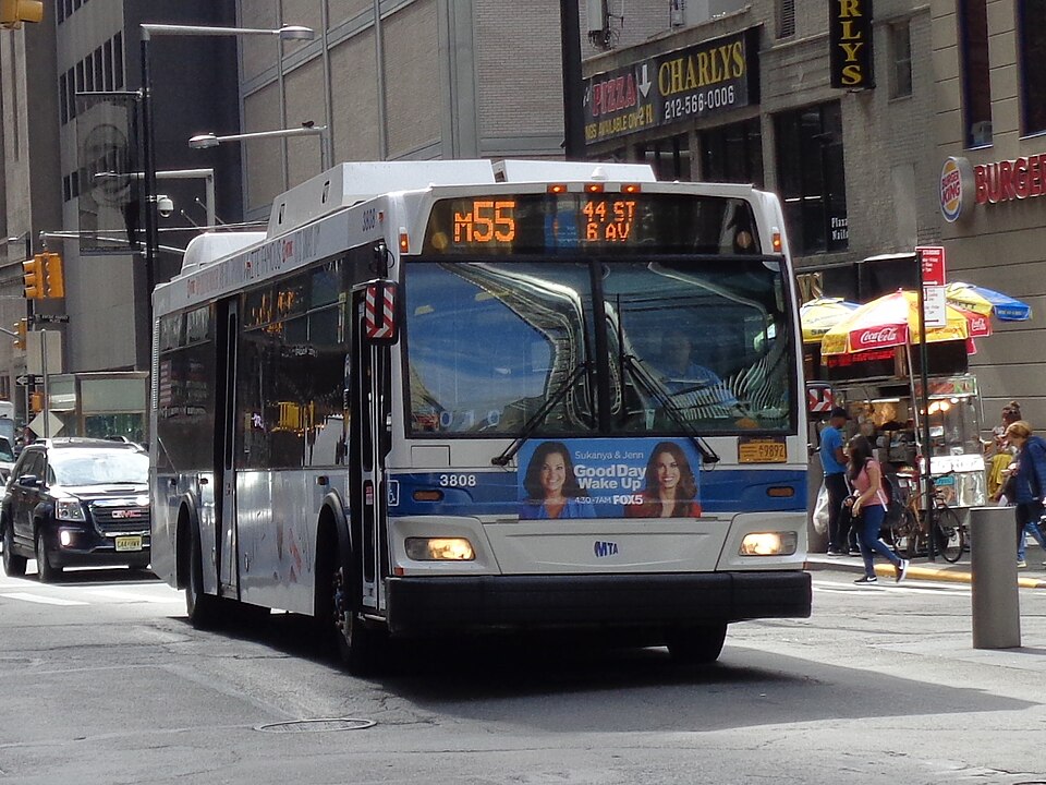 A Midtown-bound M55 bus at Church Street and Liberty Street across from 4 World Trade Center in the Financial District, Manhattan. Note the erroneous white MTA logo at the bottom of the bus above the bumper.