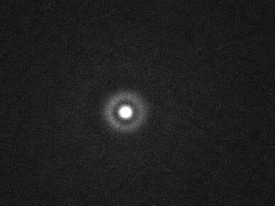 lectron microscope-style view of a single carbon atom glowing at center