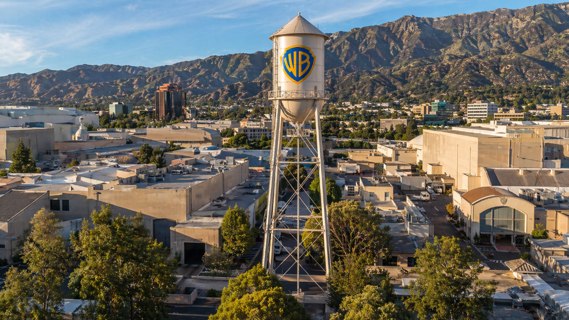 Warner Bros. water tower above a sunny studio lot and mountains