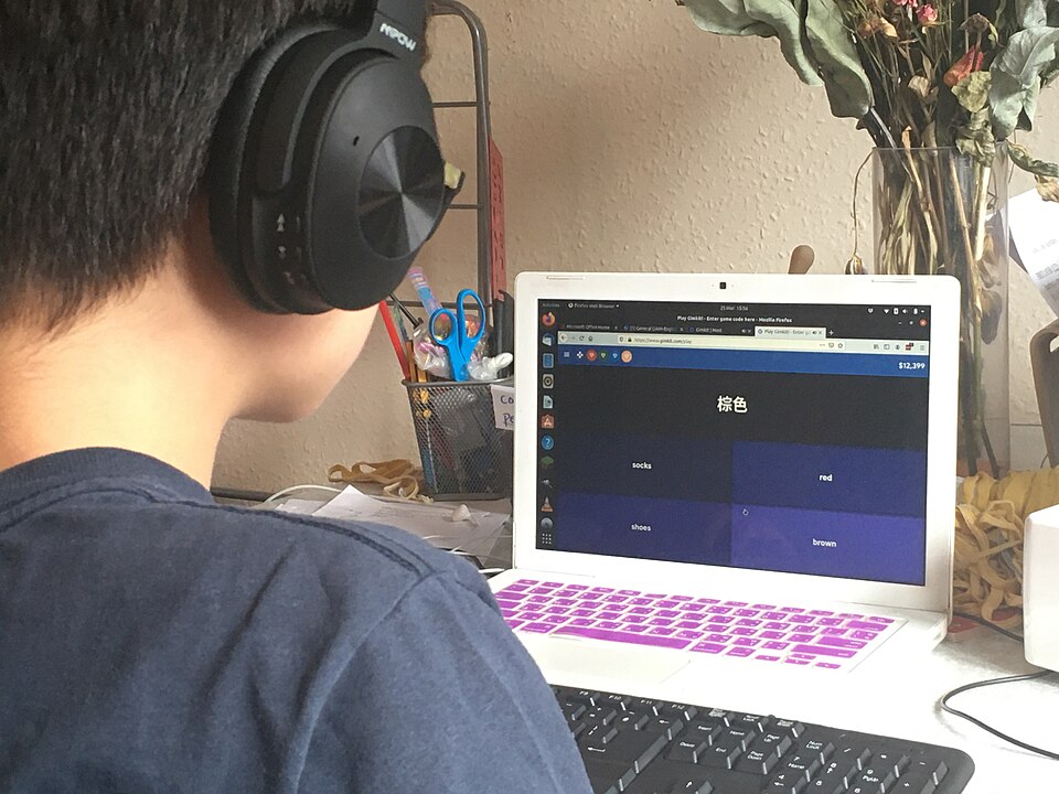 Boy with headphones looking at computer, Great Britain, Edinburgh, United Kingdom, March 2020
