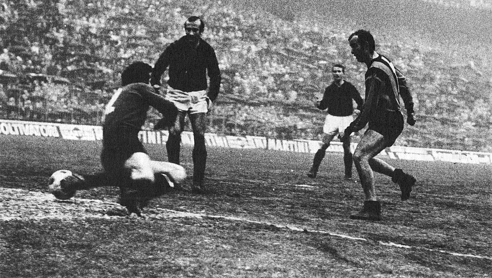 Milan (Italy), San Siro, March 8, 1970. AC Milan – Inter Milan 0-1, Matchday 23 of the Italian League 1969–70 Serie A: Inter's winger Mario Corso (right) beats Milan's goalkeeper Villiam Vecchi (no. 12) and scores at 80' the winning-goal for his team; observe the action, Milan's Giovanni Lodetti and