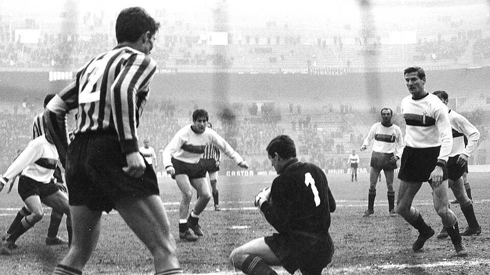 Milan (Italy), San Siro, February 25, 1967. Inter Milan – AC Lecco 1-1, Matchday 22 of the Italian Championship 1966–67 Serie A: Lecco's goalkeeper Giuseppe Meraviglia (no. 1) saves an opponent's attack; on the right, Inter Milan's left-back Giacinto Facchetti.
