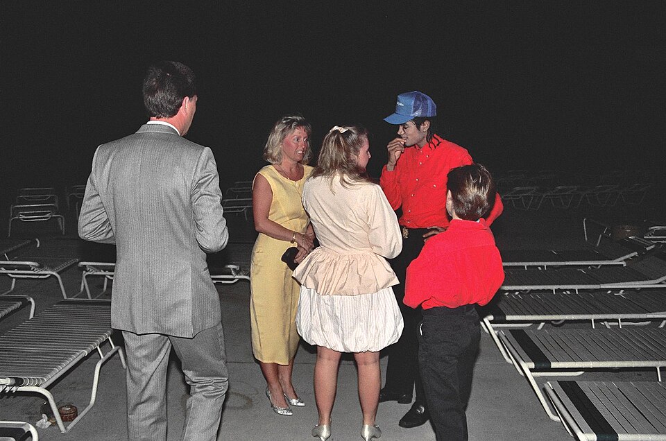 Michael Jackson talking with fans around the pool of the Kahala Hilton Hotel, early February 1988.  The small boy dressed like Michael is Jimmy Safechuck, who had appeared in a Pepsi commercial with Michael and was traveling with him.  
Scanned from the original 35MM film negative.

NOTE:  Permissio