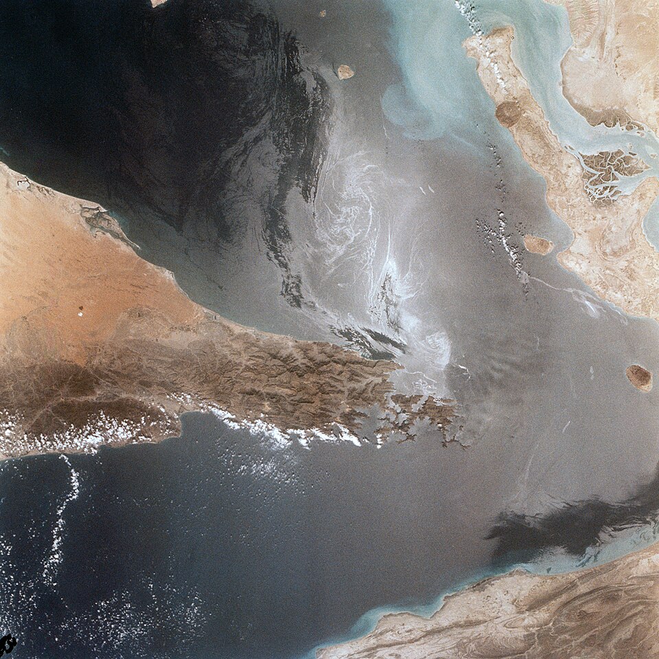Portions of Oman, The United Arab Emirates and Iran are seen at the Strait of Hormuz (26.0N, 56.0E) in this view. A number of ship wakes can be seen in the area of the strait. Sunglint in the Persian Gulf to the northwest, accentuates the complex currents and oil slicks, seen as dark toned blue stre
