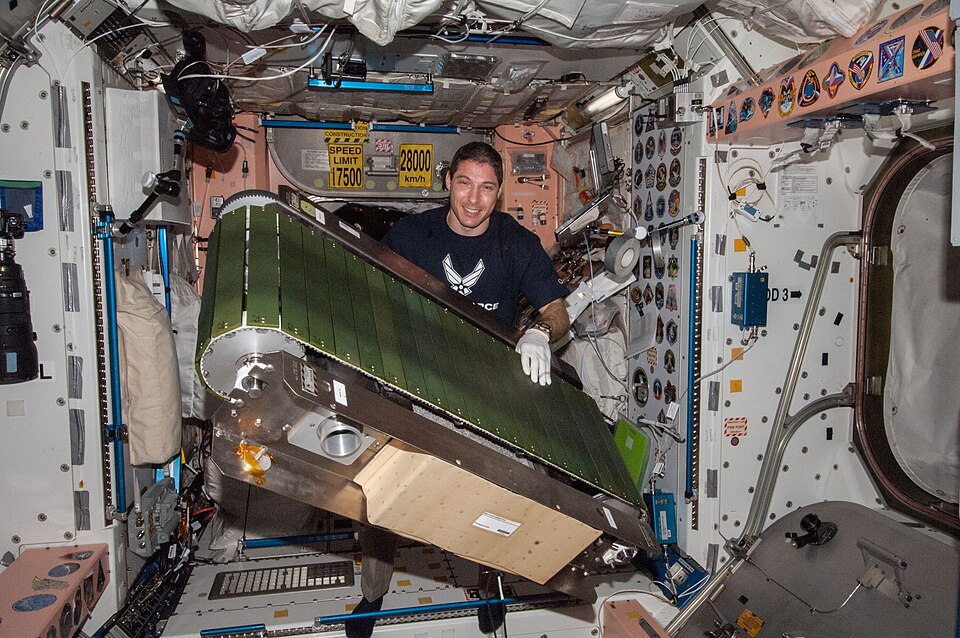 NASA astronaut Mike Hopkins, Expedition 38 flight engineer, works on the COLBERT treadmill in the Unity node of the International Space Station. He replaced a failed accelerometer in the exercise device then activated COLBERT for a speed test.