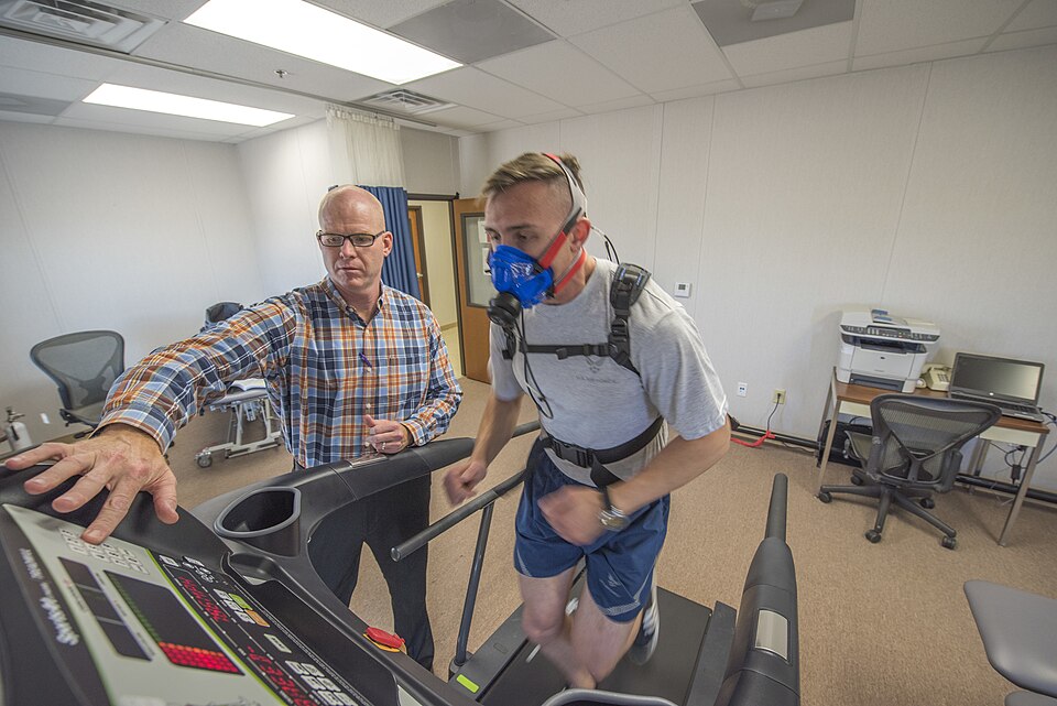 William Goins, 21st Medical Group health promotions flight commander and certified exercise physiologist, increases incline on a treadmill while 2nd Lt. Michael Horvat, 2nd Space Operations Squadron mission analyst, runs as part of a VO2 test inside Building 135 at Schriever Air Force Base, Colorado