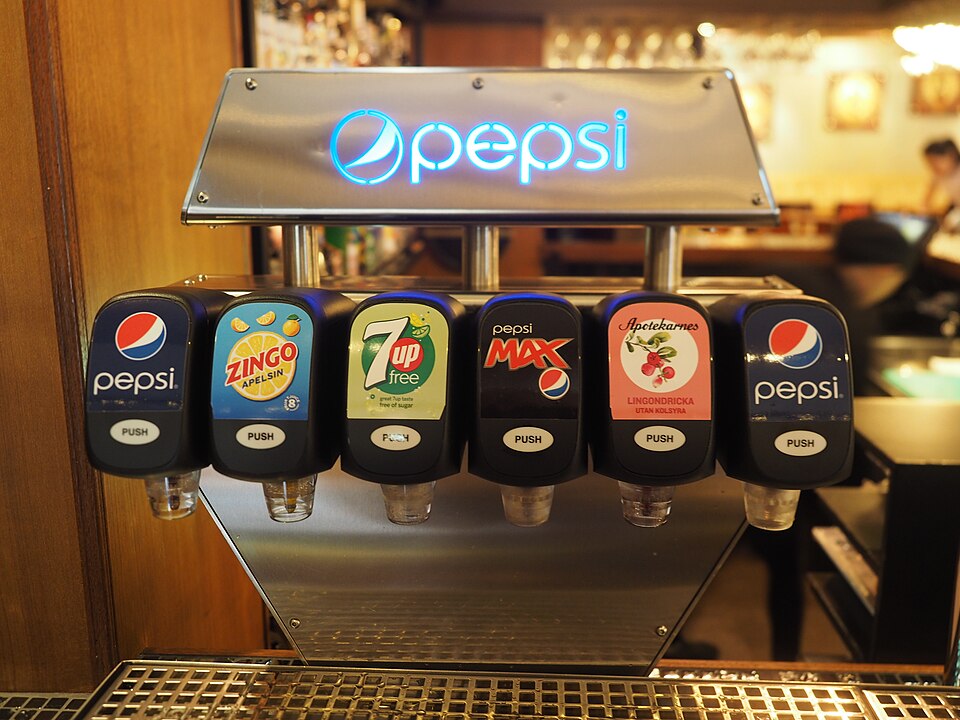 Soft drink taps at restaurant Thai Silk, Borås, Sweden. Available taps are, from left to right: Pepsi, Zingo orange soda, 7 Up, Pepsi Max, lingonberry juice, and Pepsi again.