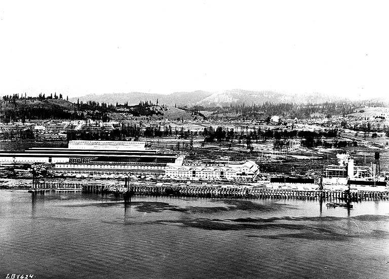 Caption on image: L.B. 1624 ; on verso of image: View shows Long-Bell industrial development as it appears from the mountains on the Oregon side of the Columbia River, a distance of approximately one mile. Buildings of the first unit of mills, structures which require 34 acres of roofing to cover, a