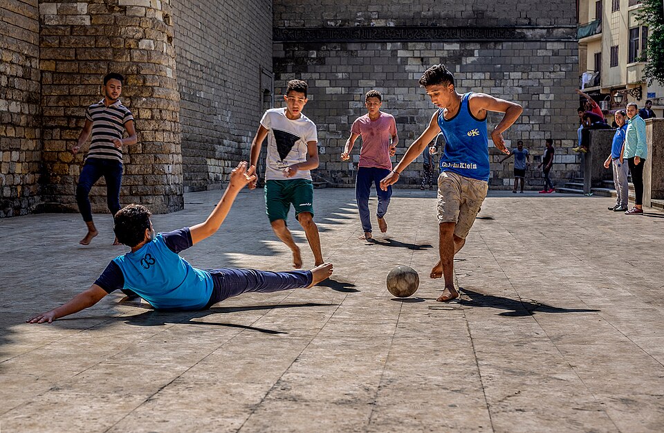 Boys playing street football in Egypt, one of the most popular games in Africa. Location is Al-Mu'izz Street, at the exterior of Al-Hakim moasque - 
Camera location30° 03′ 17.49″ N, 31° 15′ 47.37″ E View this and other nearby images on: OpenStreetMap 30.054859;   31.263158