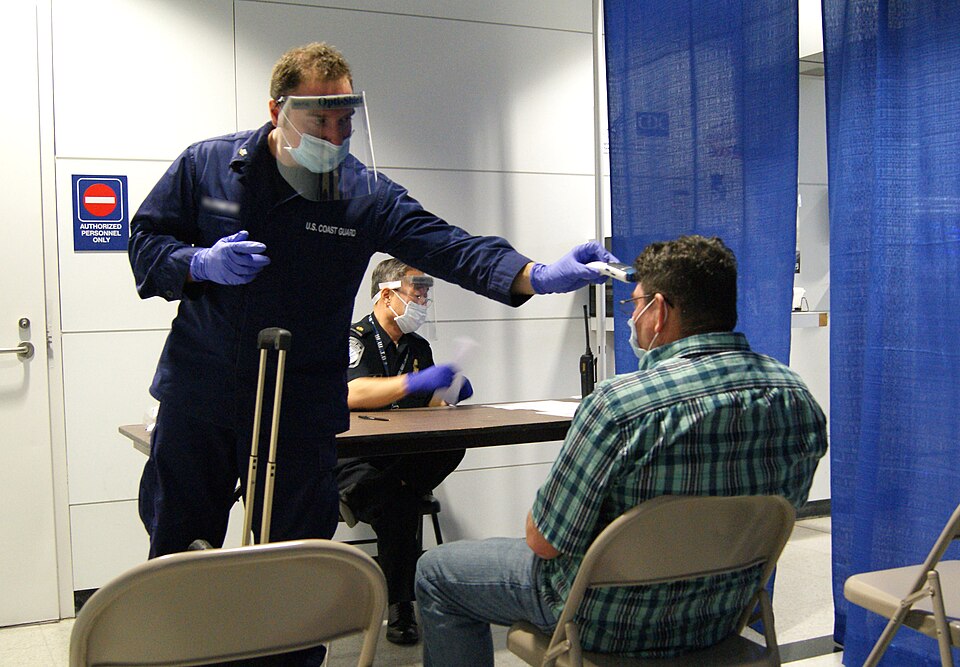 U.S. Coast Guard Health Technician and CBP Supervisor conduct prescreening measures on a passenger arriving from Sierra Leone at the at O’Hare International Airport's Terminal 5.