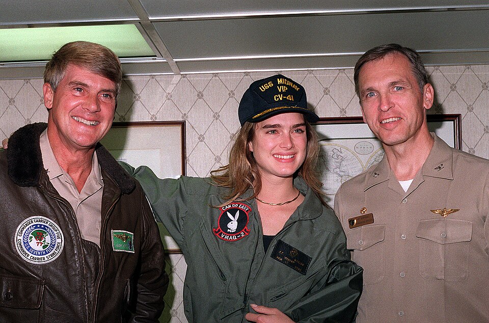 Actress Brooke Shields is flanked by Rear Adm. Daniel P. March, left, commander, Carrier Group Five, and Capt. Arthur K. Cebrowski, commanding officer of the aircraft carrier USS MIDWAY (CV-41), during her visit to the MIDWAY. Shields' visit is part of a tour sponsored by the United Service Organiza