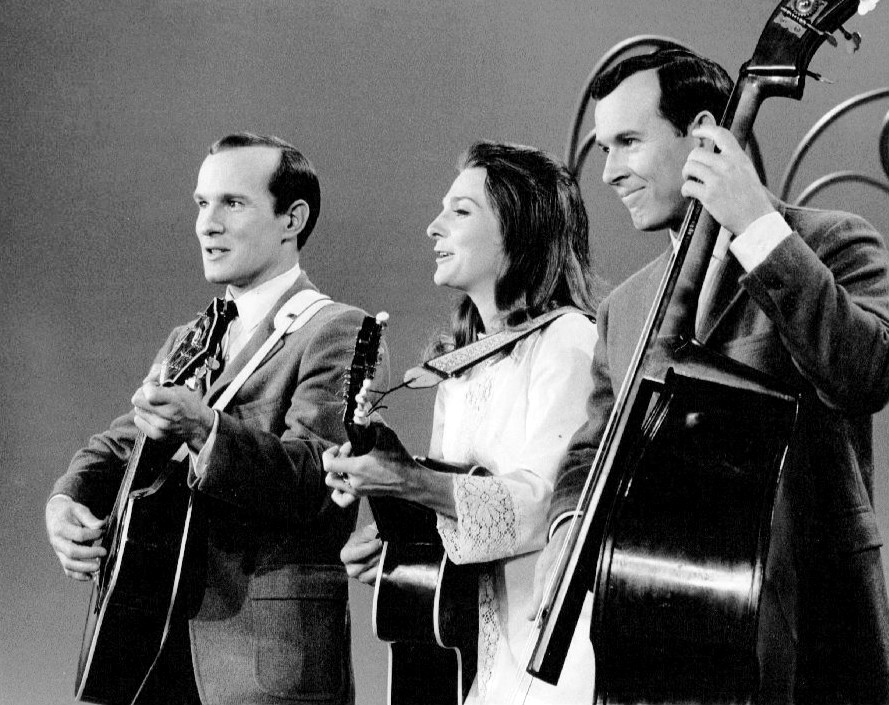 Photo of Judy Collins performing with Tom (left) and Dick Smothers on their television program The Smothers Brothers Comedy Hour.