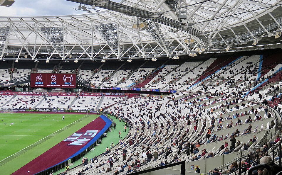 The London Stadium before a West Ham United game against Southampton with supporters socially distanced due to Covid-19 and the hygiene safety warning sign displayed.