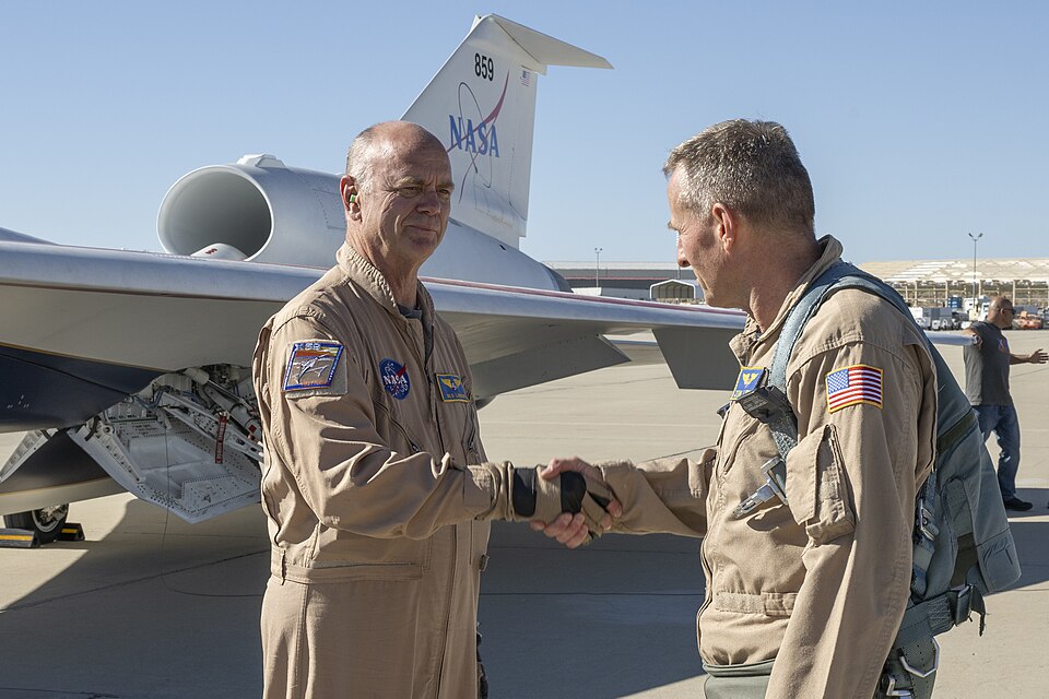NASA chase pilot Jim “Clue” Less congratulates Nils Larson after completing the X-59’s first flight on Tuesday, Oct. 28, 2025. The milestone marks a major step toward demonstrating quiet supersonic technology that could enable future air travel over land without the disruptive noise of traditional s