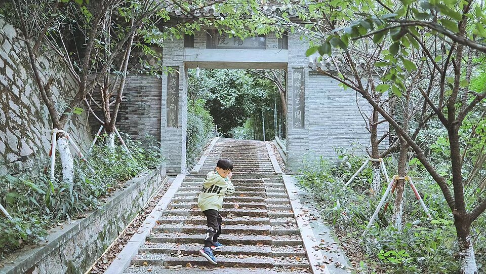 A kid running on the stairs in front of Lion Mountain Gate