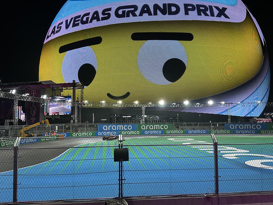A photo taken at the 2024 Las Vegas Grand Prix, featuring the Sphere (displaying a graphic of Orbi) and the Las Vegas Street Circuit's seventh and eighth turns.