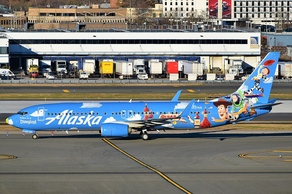 Painted in a Disneyland/Pixar/Toy Story theme, an Alaska Airlines Boeing 737-800 is taxiing to its gate at JFK Airport.