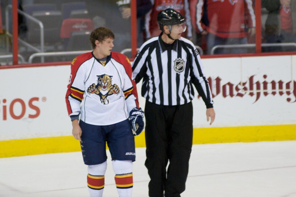 Dmitry Kulikov of the Florida Panthers being escorted by Shane Heyer during a game against the Washington Capitals.