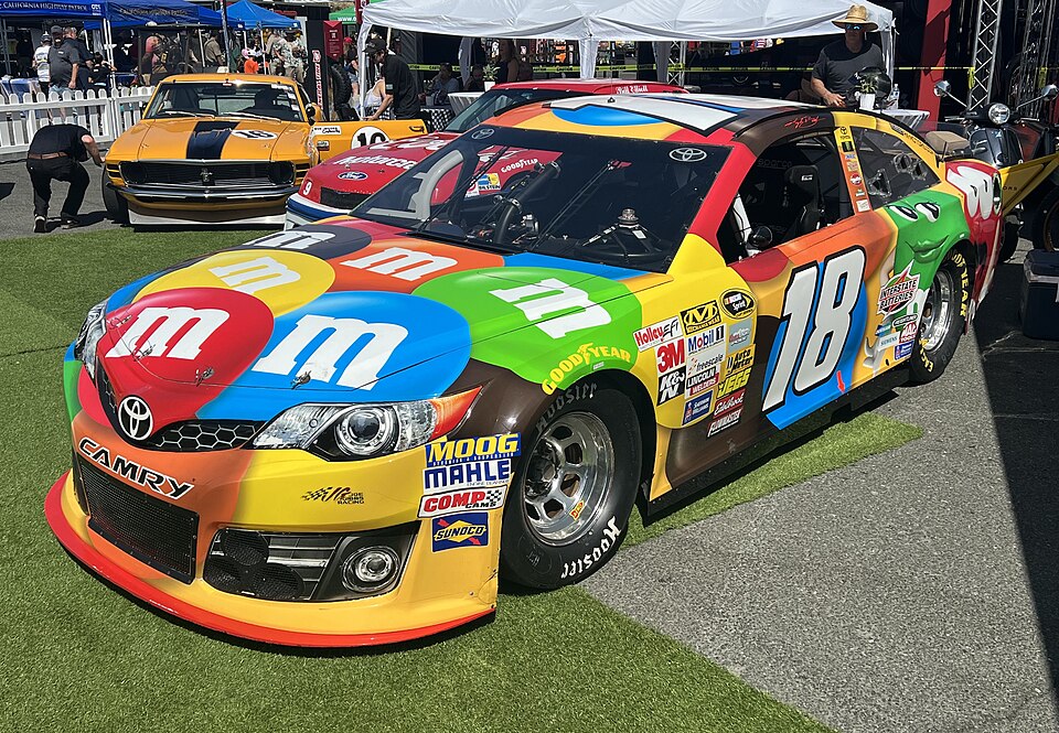 A showcar of Kyle Busch's No. 18 M&amp;M's Toyota at Sonoma Raceway in 2024.