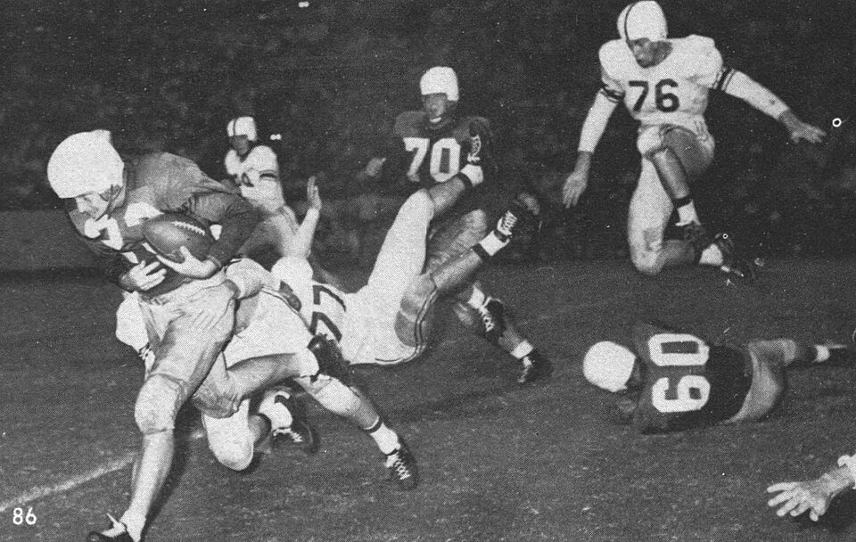 An American football game between the Houston Cougars and the Texas A&amp;M Aggies during the 1952 season.  Aggie players (Jack Little, #76; Dick Frey, #77) attempt to stop Harlan Baldridge of Houston (#23) during a rush.