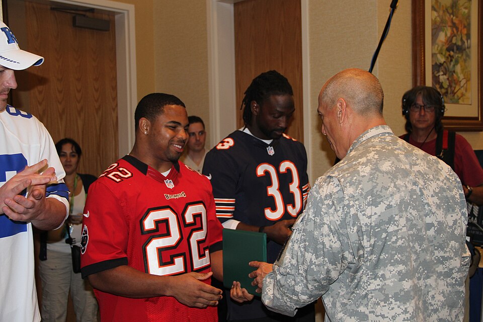 SCHOFIELD BARRACKS, Hawaii " Doug Martin, running back for the Tampa Bay Buccaneers, receives a certificate of appreciation, commander's coin and T-shirt from Lt. Col. Stanley Garcia, commander, Warrior Transition Battalion, at a wounded warrior luncheon at the Nehelani, here, Jan. 24.