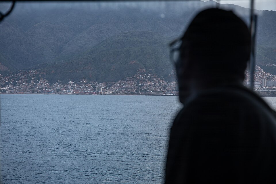 U.S. Sailor with San Antonio-class amphibious transport dock USS Fort Lauderdale (LPD 28), observes the coastline as the Fort Lauderdale sails towards the coast of La Guaira, Venezuela, June 28, 2026. At the direction of U.S. Southern Command, assigned U.S. military forces are supporting Department