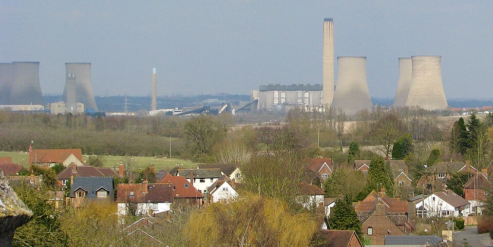 Cooling towers and chimney of Didcot Power Station, seen over the rooftops of Harwell village from St Matthew's parish church