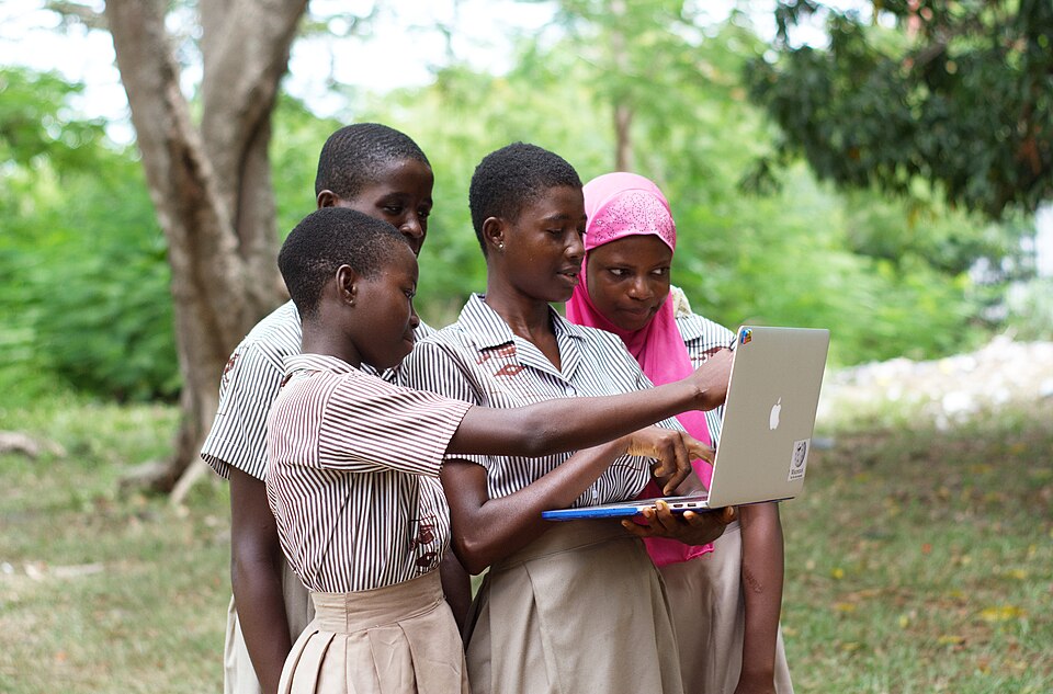 A group of female students looking on a laptop at a school in Tapa Amanya. Oti Regionn