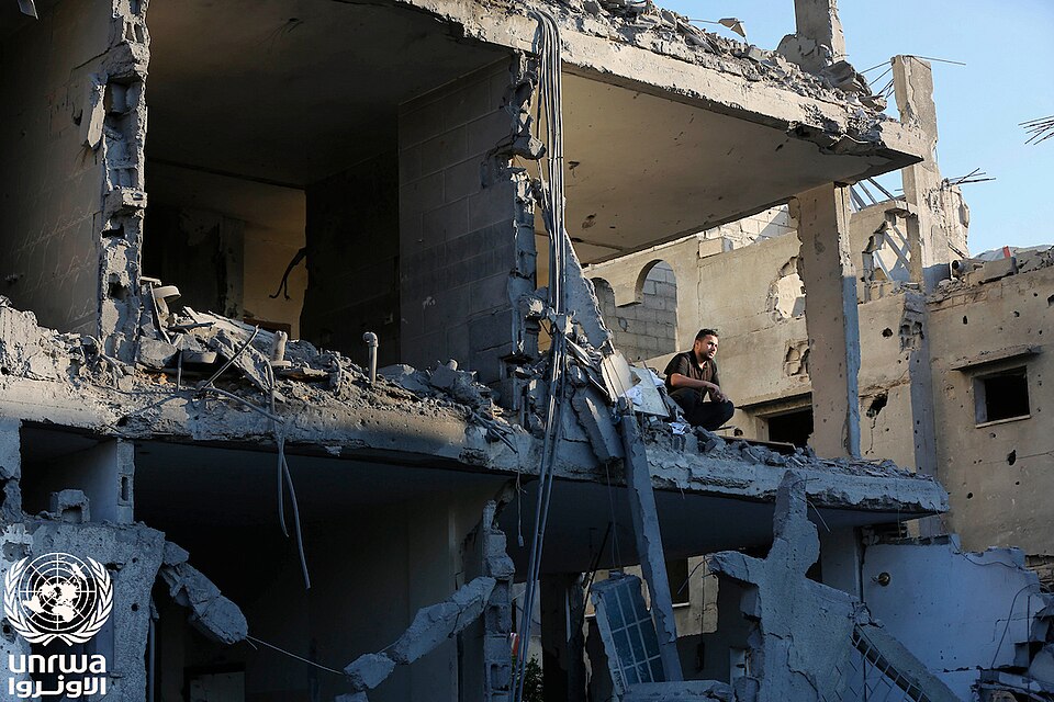 A Palestinian man sits on the rubble of his destroyed home by the Israeli bombing that continue on Deir el-Balah, Gaza Strip
