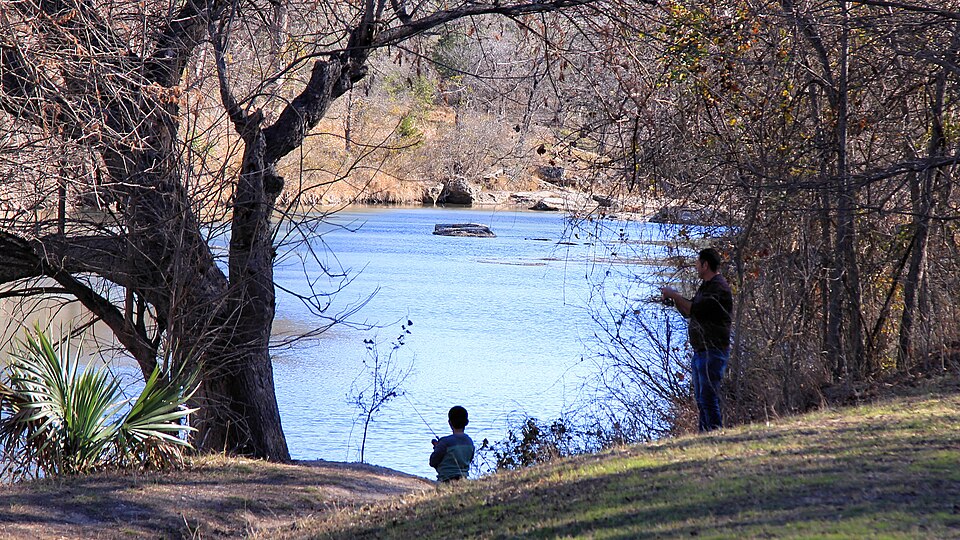 A man and his son fish in the Guadalupe River at Guadalupe River State Park near Bulverde, Texas, United States.