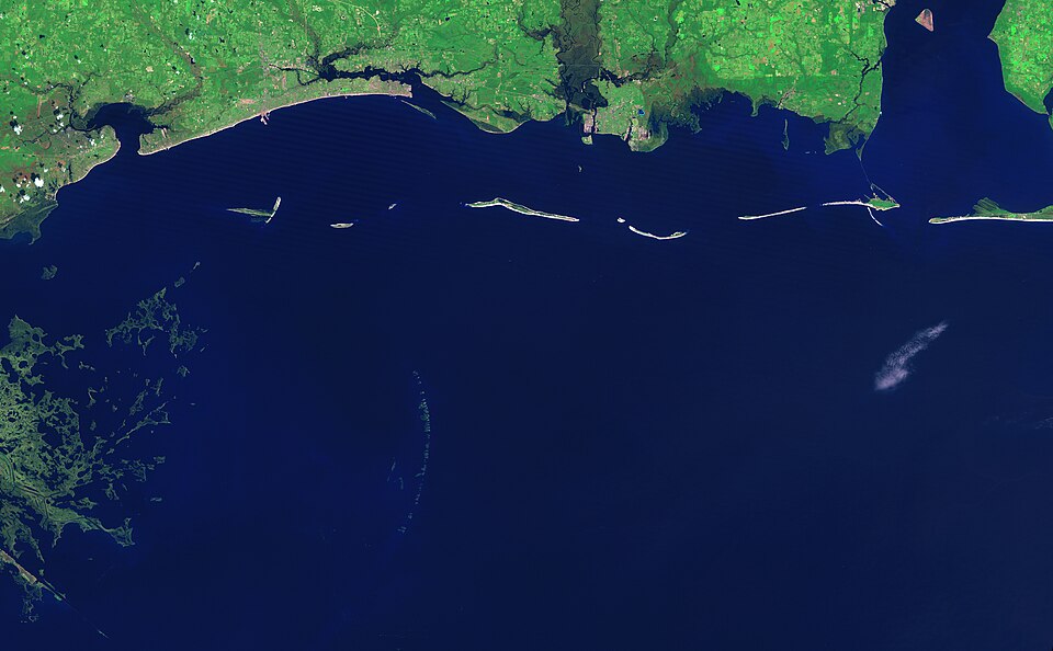 The graceful curve of the Chandeleur Islands resembles a multi-boned spine connecting the Mississippi Gulf coast to the delta of the Mississippi River in Louisiana. Like all barrier islands, the Chandeleur Islands form a thin protective wall between the open sea and the mainland, in this case Louisi