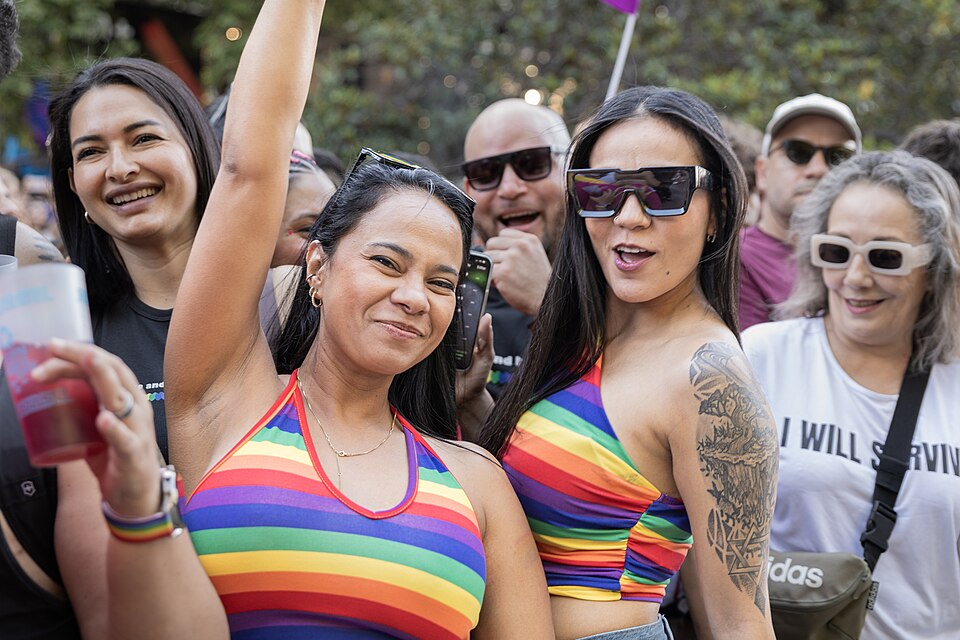 Faces of Pride: Diverse attendees at the 2024 Madrid Pride Parade smile for the camera, showcasing colorful outfits and accessories that reflect the joy and spirit of the celebration in Spain's capital.
