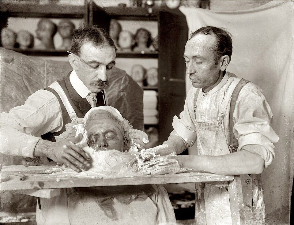 Two men making a death mask, New York, circa 1908.