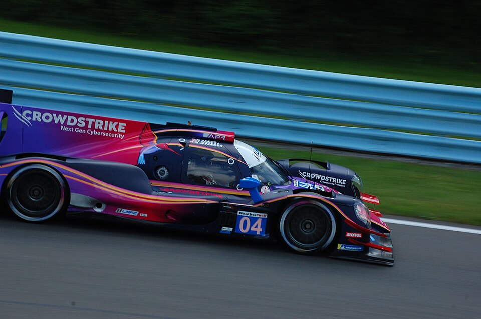 Oreca 07 of CrowdStrike Racing by APR, driven by George Kurtz, Toby Sowery, and Malthe Jakobsen, enters turn seven during the 2025 Sahlen's Six Hours of the Glen weekend at Watkins Glen International.