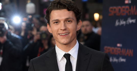 Tom Holland smiling on the red carpe