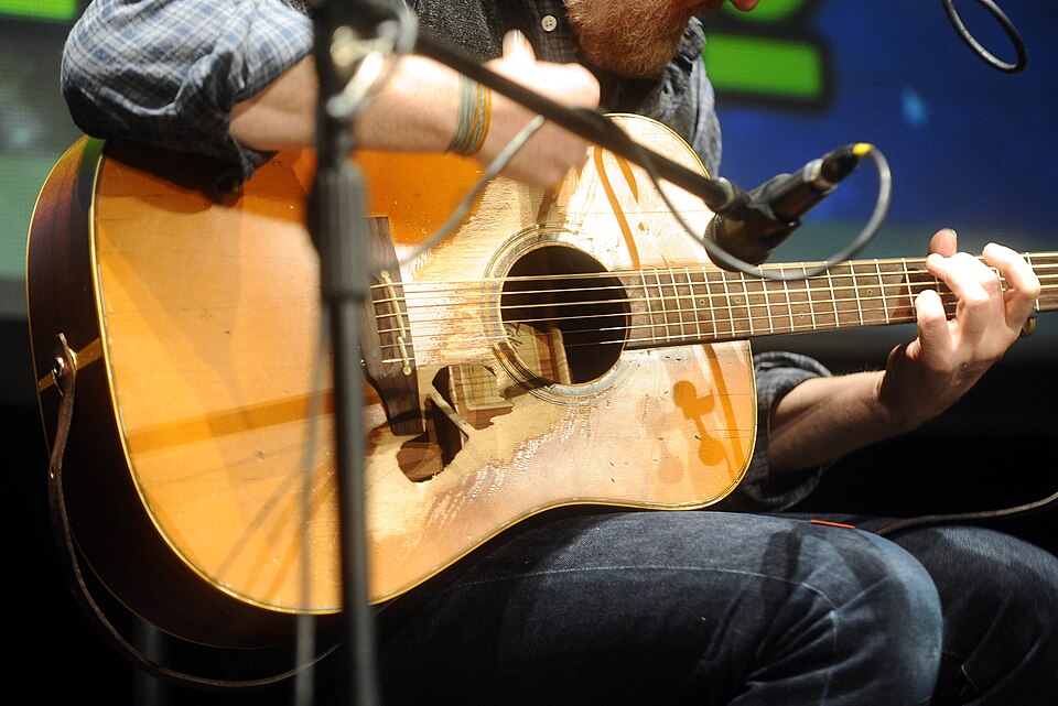 Glen Hansard's Takamine NP15 guitar, with a hole below the strings. Photo was taken during a concert at Lucca Comics &amp; Games 2015.