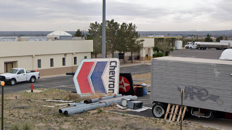 A broken Chevron sign rests in the grasslands of Vado, New Mexico.