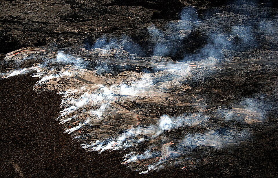 Pāhoehoe Lava flow on the coastal plain of Kīlauea, The Big Island of Hawai generated wildfire. The new lava is moving across the old surface, which is covered with a layer of moss about an inch thick. This moss is burning generating the smoke visible in the image. This kind of fire cannot be easily