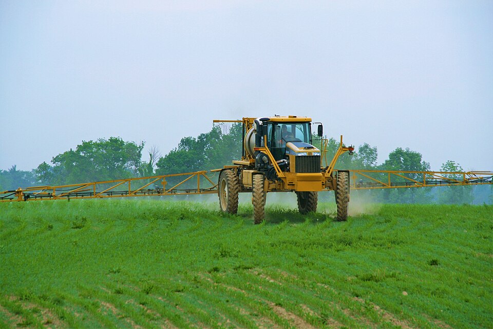 A 2007 RoGator 1264 Liquid Sprayer applying pesticide to a corn field.  Picture taken in Ontario, Canada.  The sprayer has a 90' boom and a 350HP Caterpillar engine.