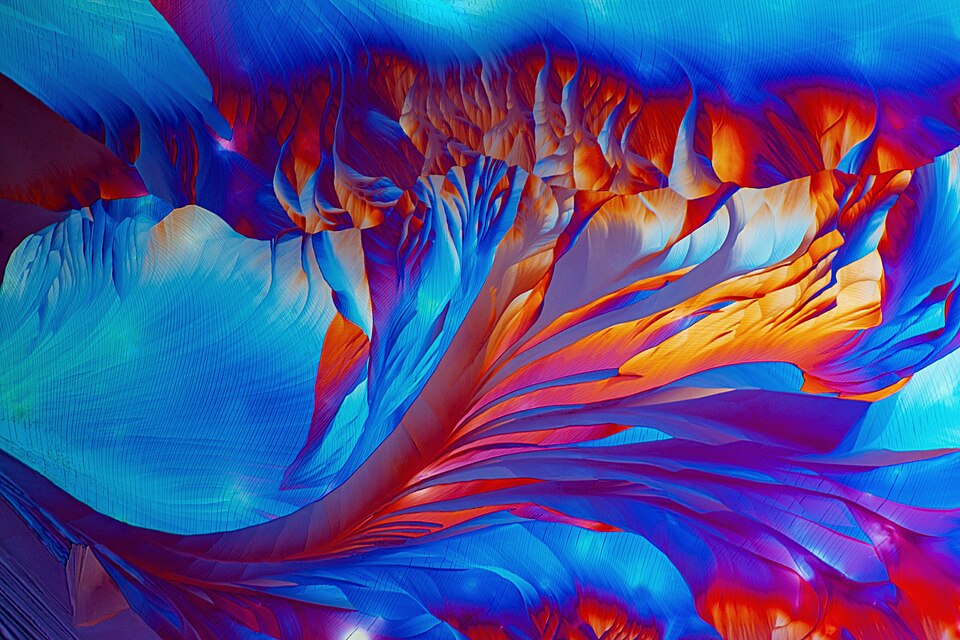 This striking image was captured using a polarized light microscope with a 10x objective lens, revealing beta-alanine crystals in extraordinary detail. The spectacular colors - vivid blues, reds, oranges, and purples - are not the amino acid's natural colors but rather emerge through an optical phen