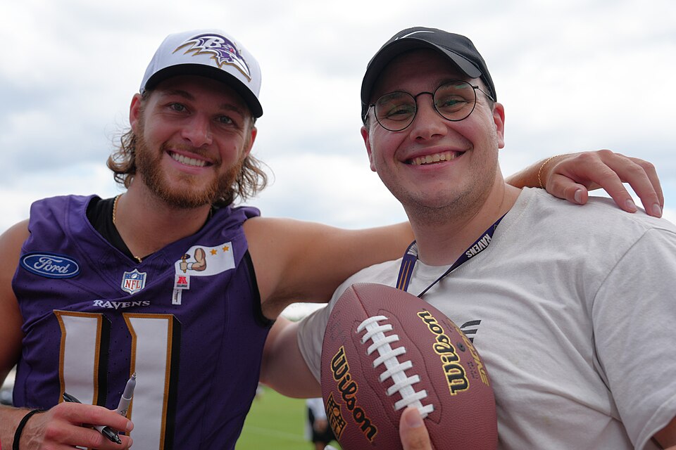 Baltimore Ravens Punter Jordan Stout takes a photo with a Fort Meade service member.
On Aug. 2, 2024, service members from Fort Meade enjoyed a luncheon at the Baltimore Ravens training facility and watched the Ravens during their training camp. While there, service members met players and got autog