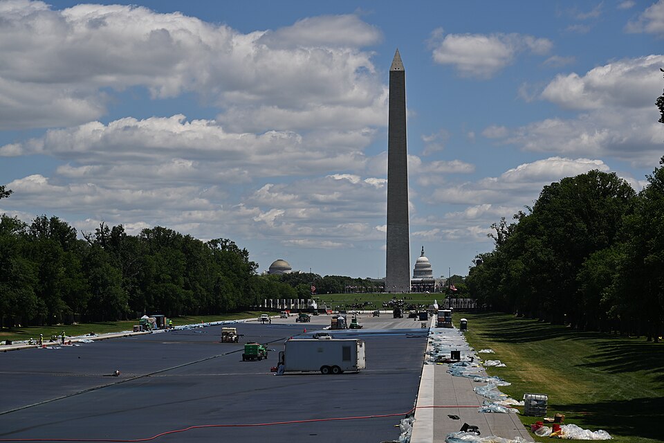 In time for the United States Semiquincentennial the Reflecting Pool between the Lincoln Memorial and the World War II memorial is being painted a deep blue. This is a view looking towards the WWII memorial with the Washington Monument and the Capital dome in the background.  National Mall, Washingt