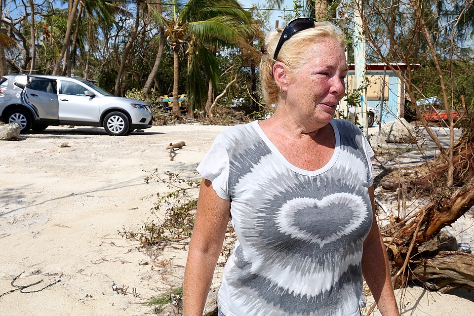 Dixie Crystal Mathews wipes away tears as the American flag is raised above the sea. “We are going to get through this,” she said. “Now we know it’s going to be okay.” (R. Taylor/VOA)