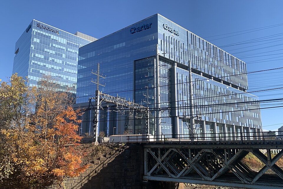Headquarters of Charter Communications, (also known as Spectrum), located at 400 Washington Boulevard in Stamford, Connecticut, USA. A bridge carrying the New Haven Line (part of the Northeast Corridor) over the Rippowam River is visible in the foreground.