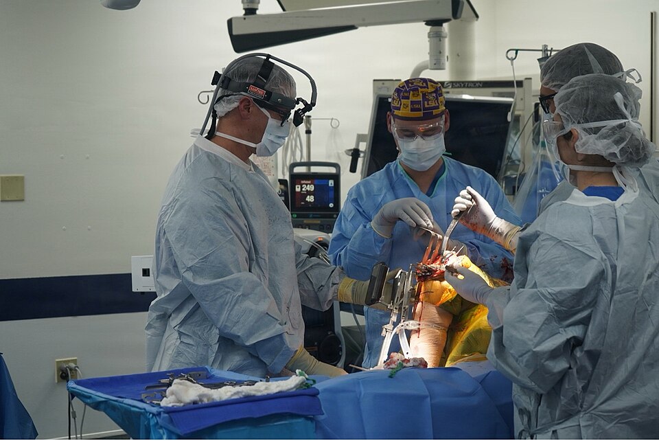 260202-N-FT324-8515. ROTA, Spain (February 2, 2026)-Pictured left, Cmdr. Brian Barlow, orthopedic surgeon assigned to Navy Medicine and Training Command Rota, performs a computer-assisted knee replacement procedure with his surgical team at Naval Hospital Rota, Spain, using navigation technology to